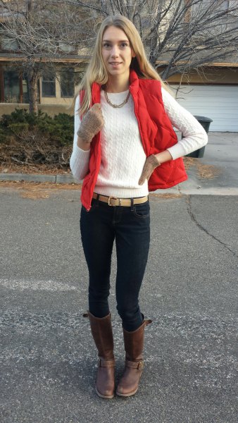 red vest with white cable knit sweater with black neck with black skinny jeans