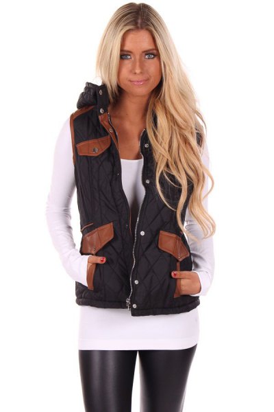 black hooded vest with white shape and long-sleeved tee and leather leggings
