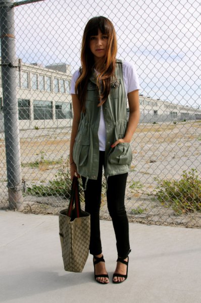 white tee with long military vest and black sandals