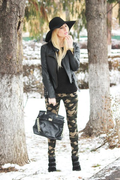 black leather jacket with skinny camo jeans and floppy hat