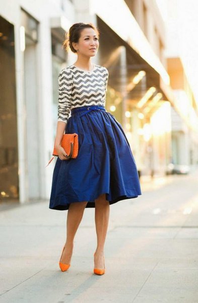 black and white patterned top with royal blue flared skirt and orange heels