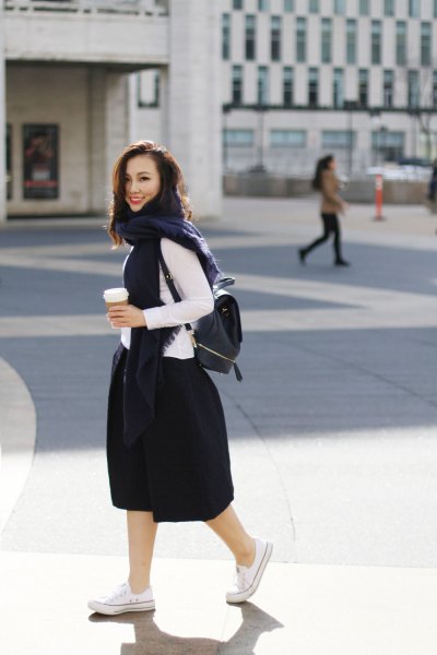 white long sleeve top with black puffy midi skirt and backpack