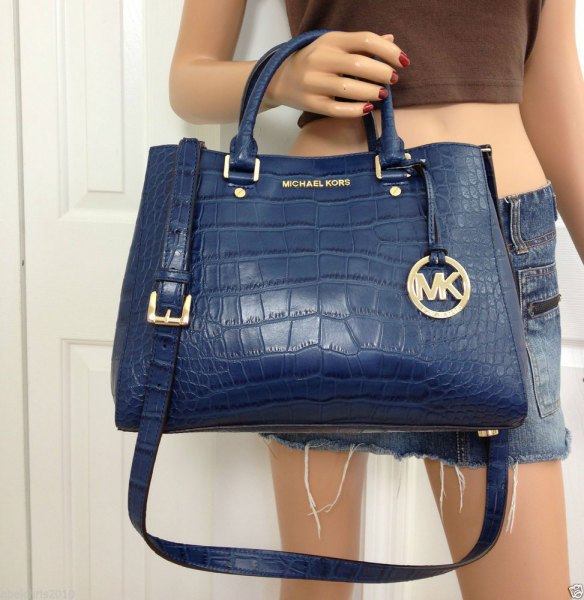 navy blue leather bag with green crop top and mini shorts