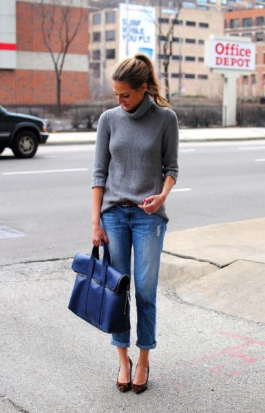 gray turtleneck knit sweater with blue cuffed jeans and matching portfolio