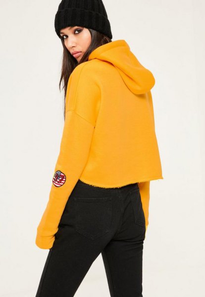 mustard yellow cropped hoodie with black jeans in high waist