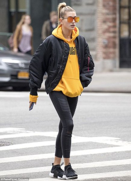 yellow hoodie with black bomber jacket and cropped leggings