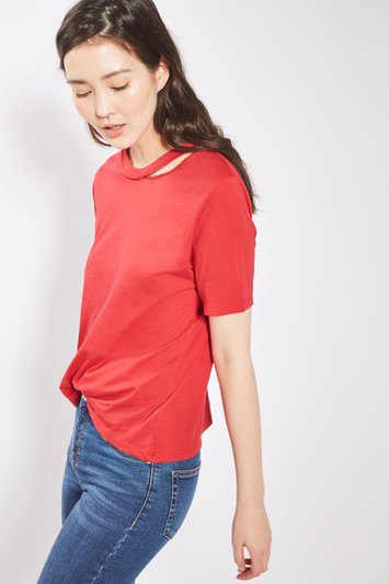 red cut-out t-shirt with blue slim cut jeans and sneakers
