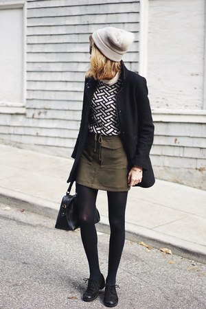 black and white patterned sweater with green mini-tie at the waist