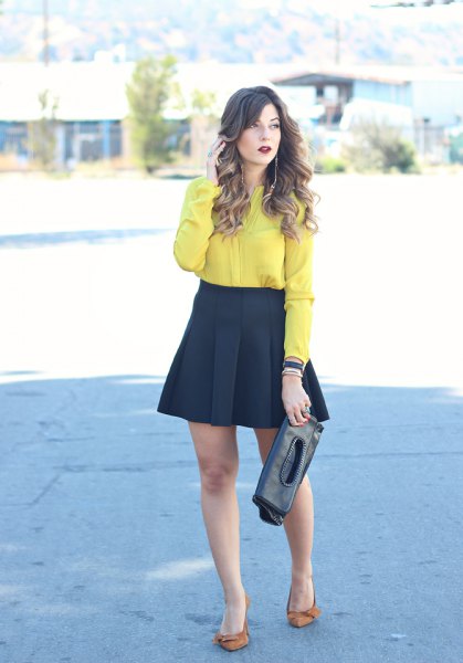 yellow button up shirt with black mini blown out and pleated skirt