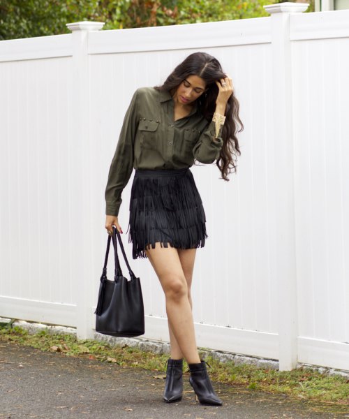 green front pocket button up shirt with black mini fringe skirt and boots