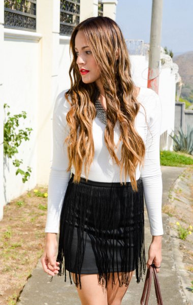 white long sleeve form tee with black mini bodycon fringed skirt