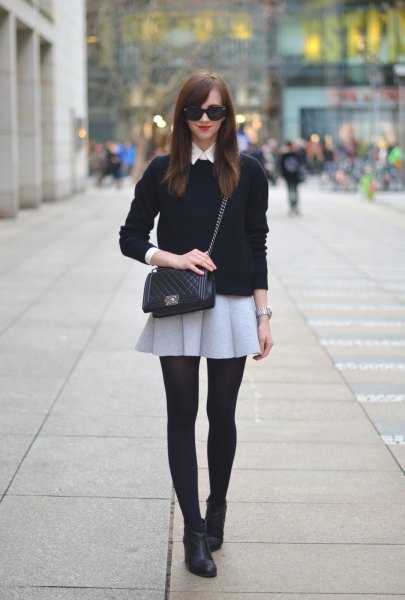 black sweater with light gray mini wool skirt