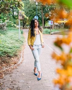 bomber jacket with white scoop neck vest and light blue jeans