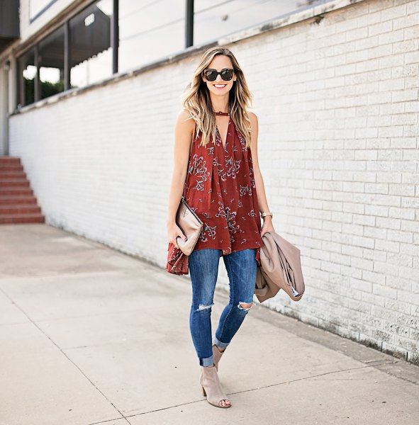 red v-neck sleeveless tunic with blue ripped skinny jeans