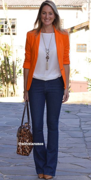orange half-heated blazer with white top and dark blue blown jeans