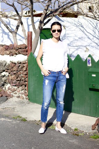 white sleeveless top with blue crop jeans and leather case