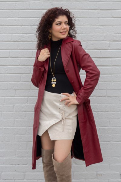 brown leather trench coat with black sweater and pink skirt