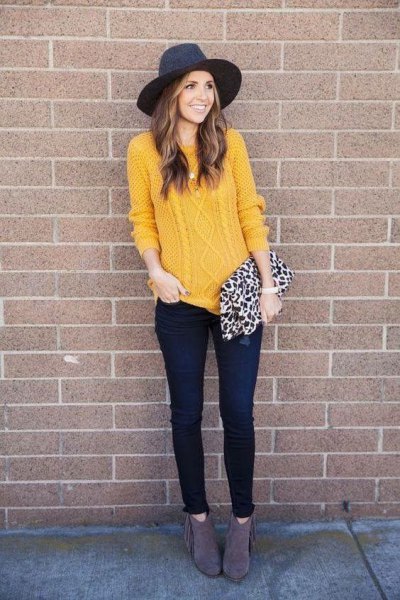 yellow cable knit sweater with black felt hat