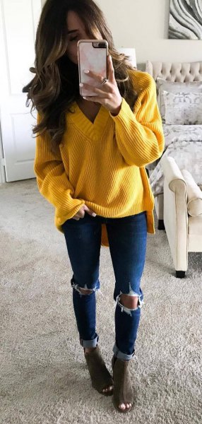 yellow v-neck chunky knitted sweater with blue skinny ripped jeans