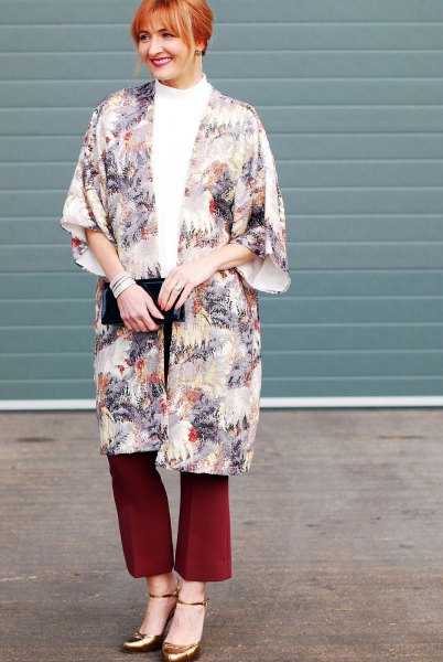 flora printed long cape with red flared pants and bronze heels