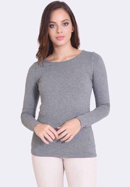 gray form fitting long sleeve top with white skinny jeans