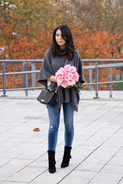 gray poncho shirt with blue skinny jeans and black boots