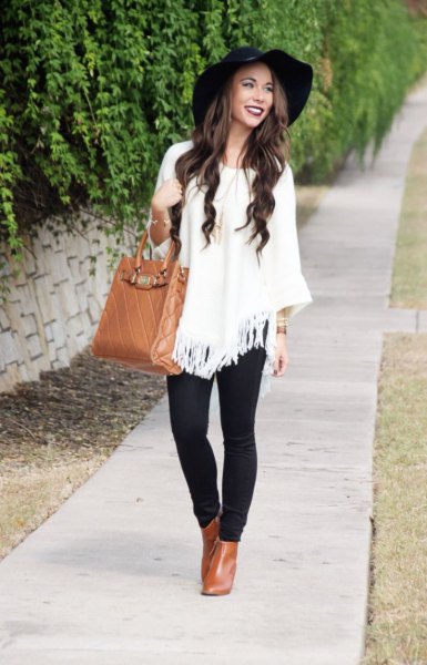 white fronts poncho sweater with black floppy hat