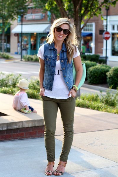white print tee with denim vest and green skinny jeans