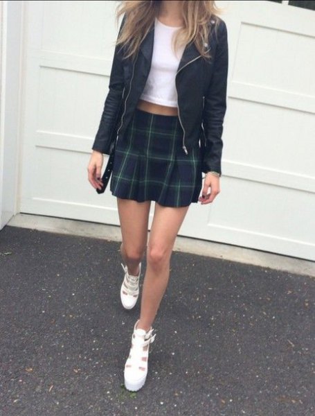 white cropped tee with black leather jacket and green checkered mini skirt