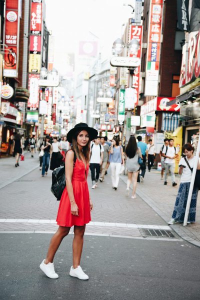 red mini sundress with white sneakers and black felt hat