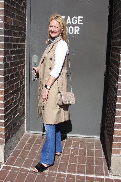 camel sleeveless coat with blue puffed jeans