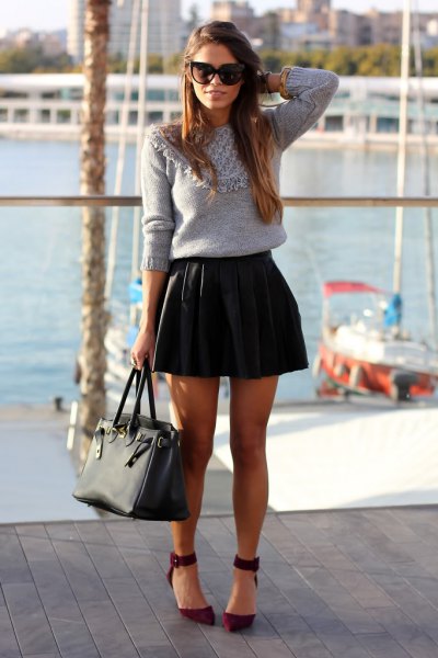 gray knitted sweater with black folded skirt in black leather