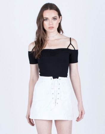 black cold shoulder top with white lace up denim skirt