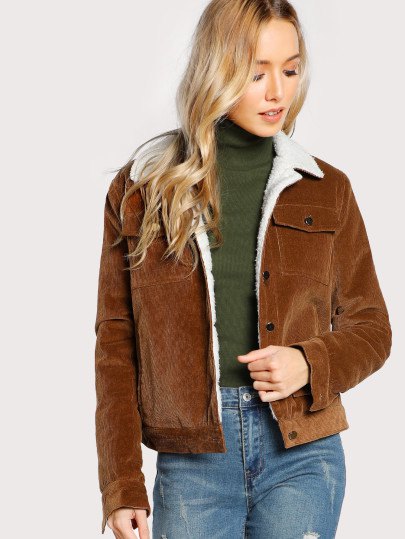 brown sherpa lined jacket with green sweater neck and jeans