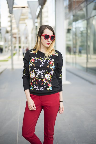 black embroidered sweater with red jeans