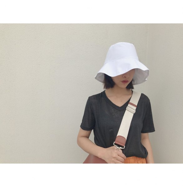 white bucket hat with dark gray tee orange midi skirt