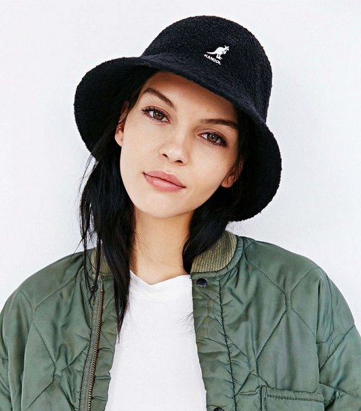 black bucket hat with white tee and green bomber jacket