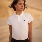 Woman in white Polo shirt with navy Polo Pony at che