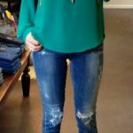 Teal blouse with long pendant necklace + distressed jeans + cognac .
