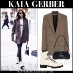 Kaia Gerber in brown oversized blazer, leather pants and white .